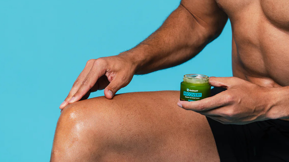 Man applying recovery salve on knee