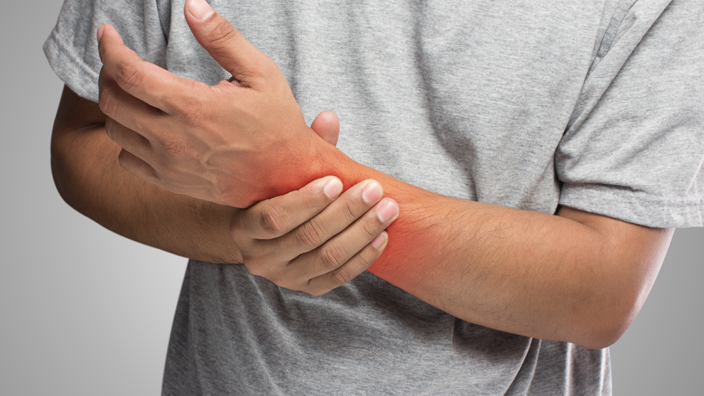 Man pressing a part of his forearm due to nerve pain